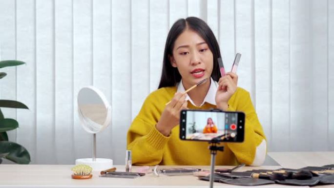 4k视频片段的年轻亚洲女性博客录制vlog视频教程和评论推广产品与化妆化妆品在社交媒体直播