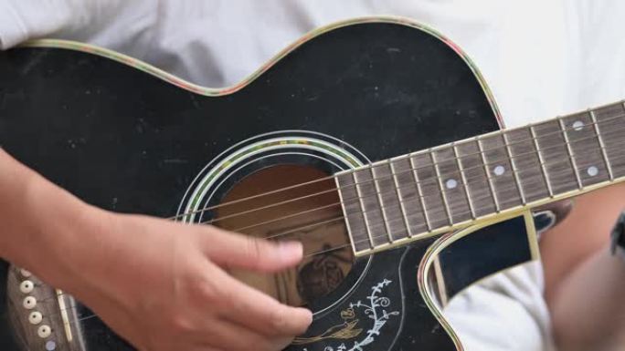 一名男性音乐家使用吉他演奏音乐。