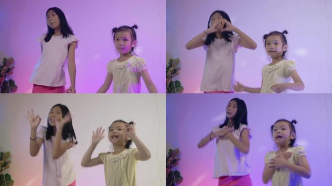 快乐的亚洲女孩在家用发光二极管背景跳舞，在家聚会。