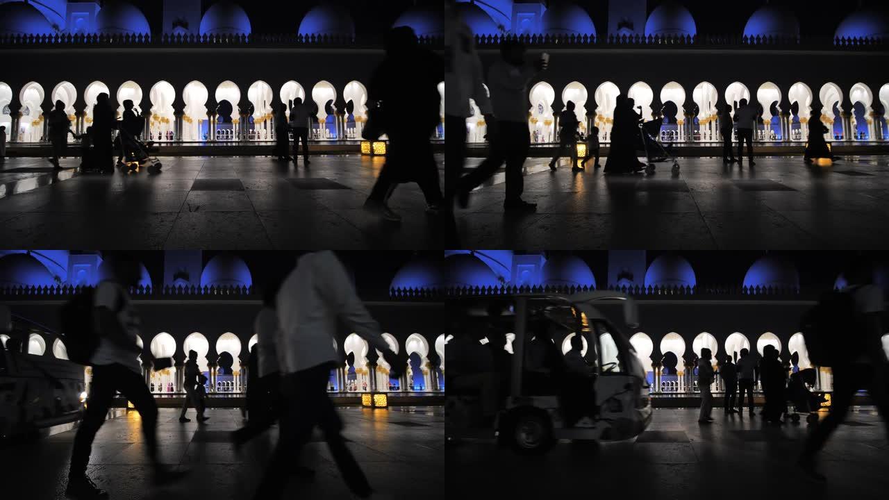 游客的剪影在阿布扎比清真寺的背景下行走