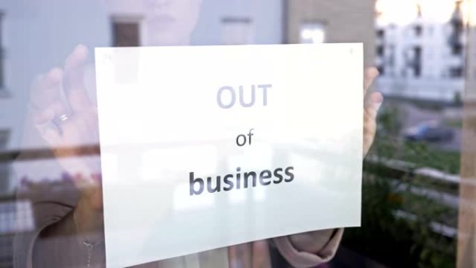 该机构的女老板在窗户上挂了一个营业标志。新型冠状病毒肺炎大流行对中小企业的影响
