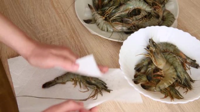 女孩准备虾做饭。浸泡并切断厨房的触角。白虾准备烹饪虾清洗