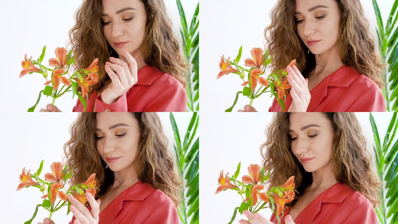 一位美丽明亮的年轻棕色头发女孩的肖像，卷发和雀斑，穿着鲜艳的橙色外套，手里拿着一朵花，看着花