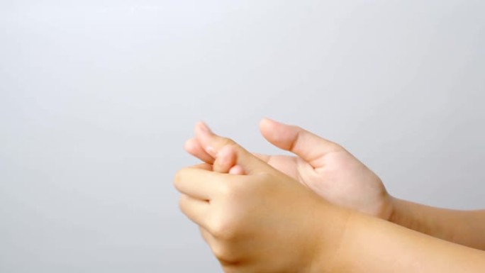 年轻的亚洲妇女使用保湿霜来滋养双手