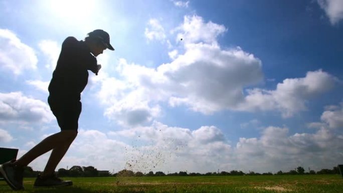 慢动作: 剪影亚洲年轻人在高尔夫球场上打高尔夫球运动员锻炼身体健康