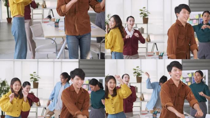 亚洲开发人员在办公室跳舞，获得有关项目的新内容。同事祝贺办公室的朋友