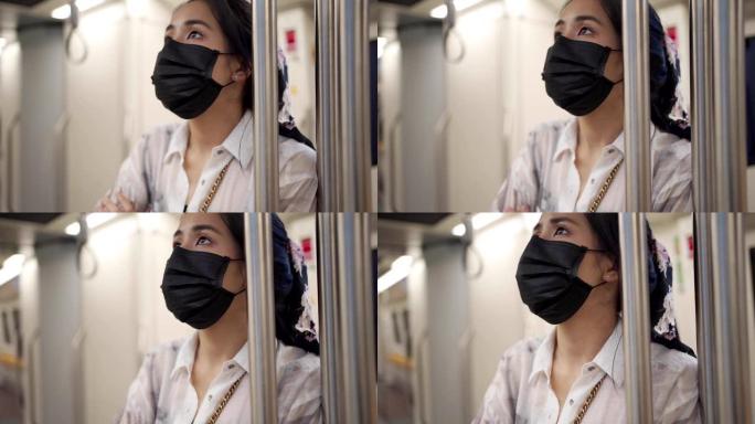 亚洲女青年戴黑色防护口罩地铁列车上看车站时间表新常态社交距离生活方式自我保护空地铁车厢传染风险警示慢