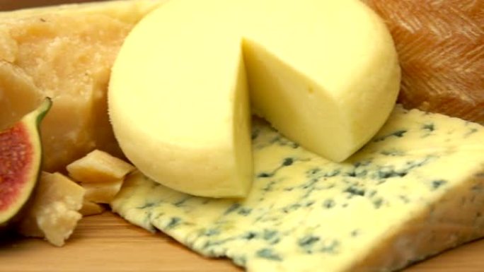 各种各样的法国奶酪放在成熟的枣果旁边的板上