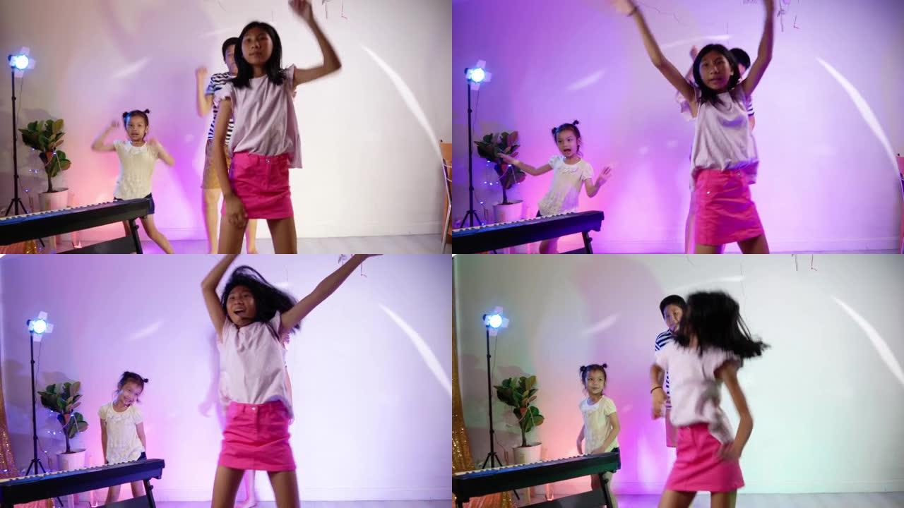 快乐的亚洲孩子在家用发光二极管背景跳舞，在家聚会。