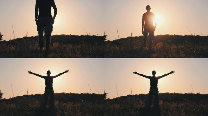 年轻人在野外散步到夕阳并举起双手的剪影