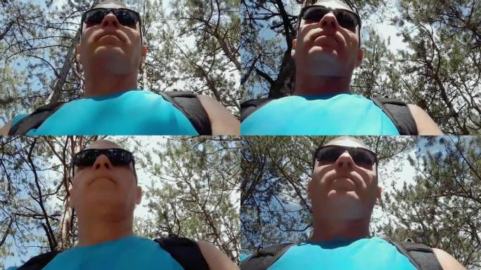 一名男子在夏日穿过树林的眼镜，相机底部视图