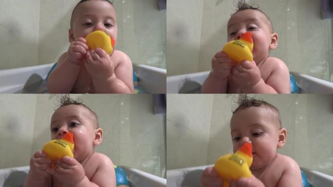 浴缸里可爱的可爱宝宝把黄鸭放进嘴里