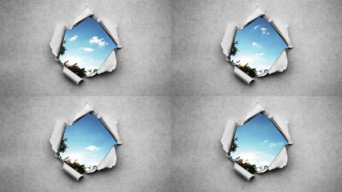创意4k时间圈视频，在蓝天中快速移动的云，可以通过旧复古垃圾老式纸的边缘撕裂的圆形孔看到。