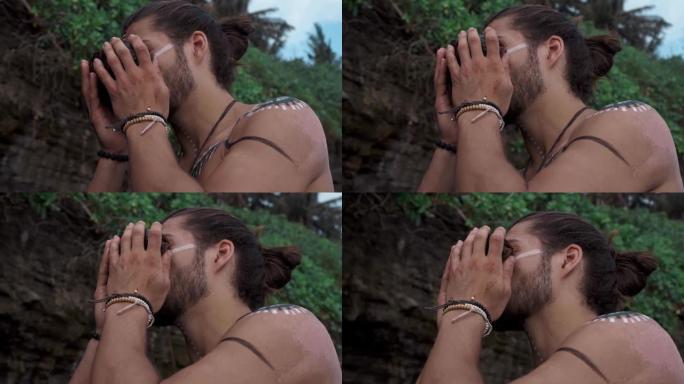 一名身体上有画的欧洲男子手里拿着一个椰子，喝着水