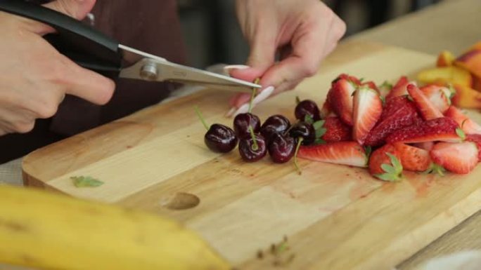 手女人在木板上切梨素食成分烹饪成熟水果板烹饪食物新鲜健康