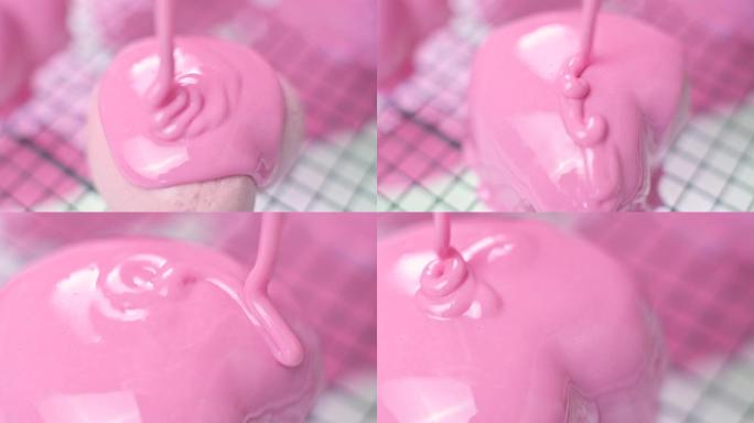 将粉红釉糖霜以心形倒在冷冻的粉红蛋糕上
