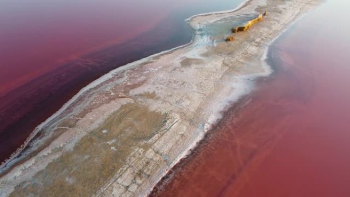 在粉红色的盐湖上的盐岸吐痰顶部的鸟瞰图，其中底部的盐和粘土含量具有愈合特性。