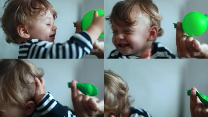 用气球吹向孩子的脸。向微笑的婴儿放气气球