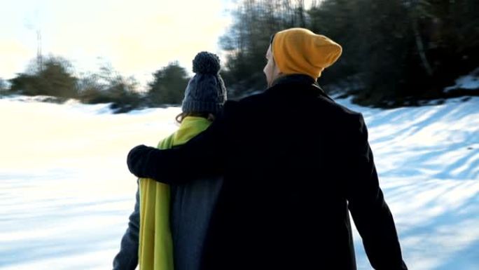 拥抱的夫妇走过雪地