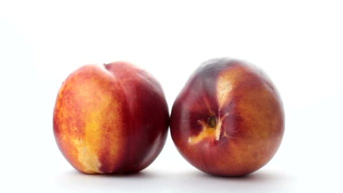 新鲜多汁的桃子放在白色盘子里。特写新鲜有机桃子油桃放在白色盘子上。