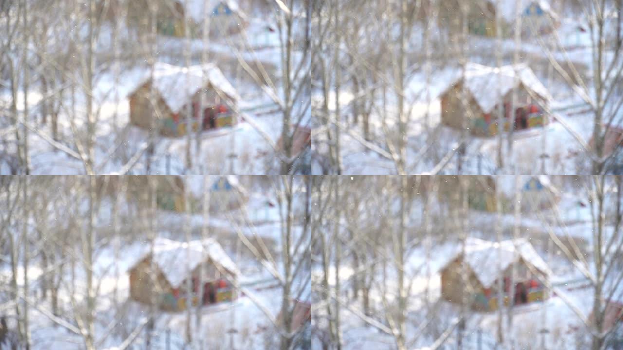 冬季降雪。蓬松的雪花飞舞，随风旋转。雪中可爱的木屋。圣诞节散焦抽象背景。新年假期。冬季大销售和礼品广