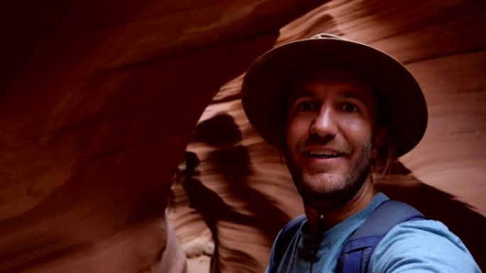 年轻人在美国羚羊峡谷自拍。在狭窄的峡谷中徒步旅行的旅行者会自拍。沙漠中的自拍时间，壮观的岩石形成