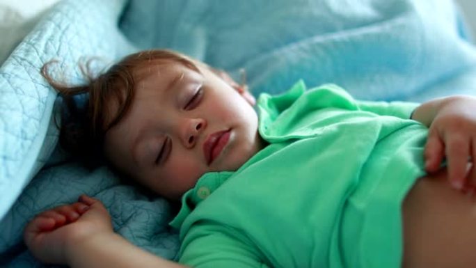 婴儿午睡时睡在床上。宁静平静的婴儿男孩睡着打盹