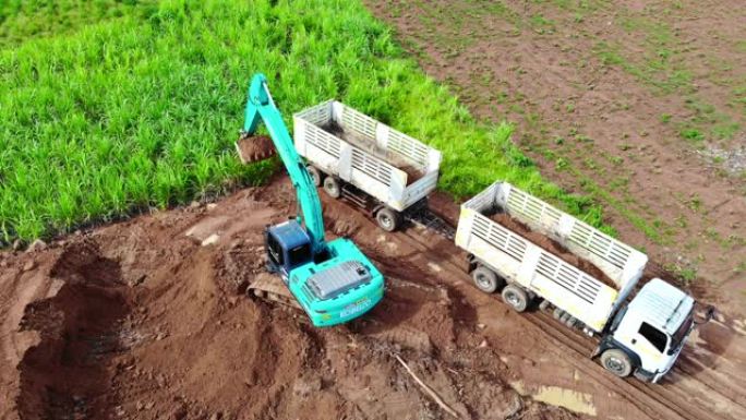 反铲将土壤装载到卡车中，然后卡车将土壤出售。
