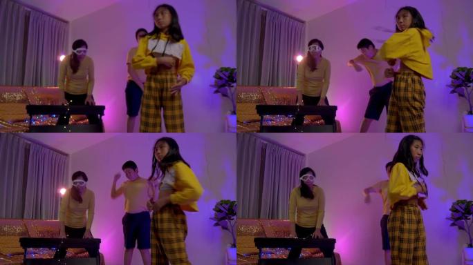快乐的亚洲妈妈和两个孩子在客厅用led灯一起跳舞，生活方式理念。