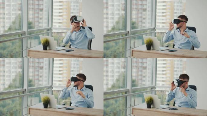 一个坐在办公室办公桌前的年轻人使用增强现实眼镜从事各个领域的商业项目。