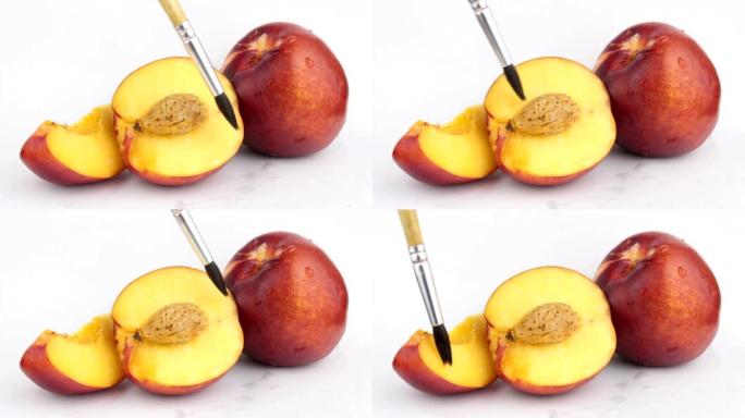 艺术家用刷子在桃子上画画。艺术家的画笔特写。一滴水顺着新鲜多汁的桃子流下来。