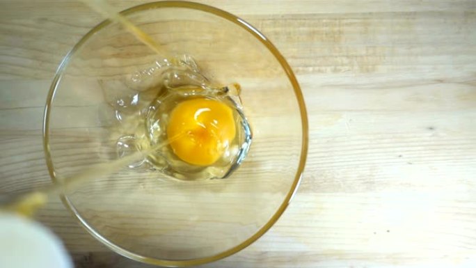 生鸡蛋以慢动作落入碗中。