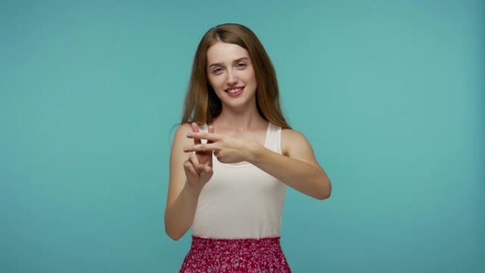 可爱的正面女孩穿着夏装，用交叉手指展示标签符号，标记流行的互联网信息