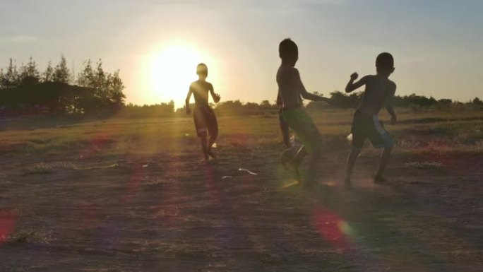 日落时分，农村孩子正在踢足球。慢动作