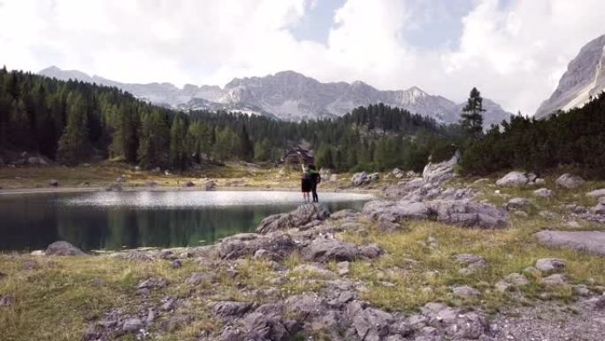 斯洛文尼亚特里格拉夫国家公园湖旁的一对男女站在岩石上的空中镜头