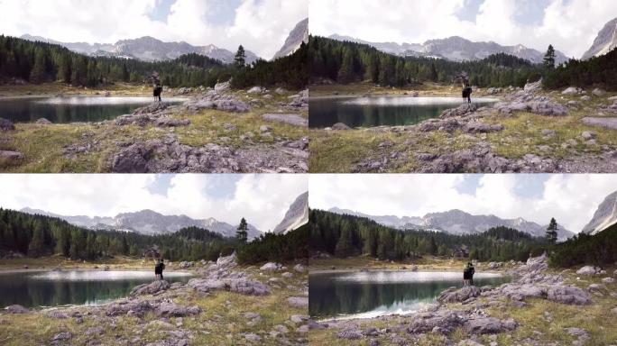 斯洛文尼亚特里格拉夫国家公园湖旁的一对男女站在岩石上的空中镜头