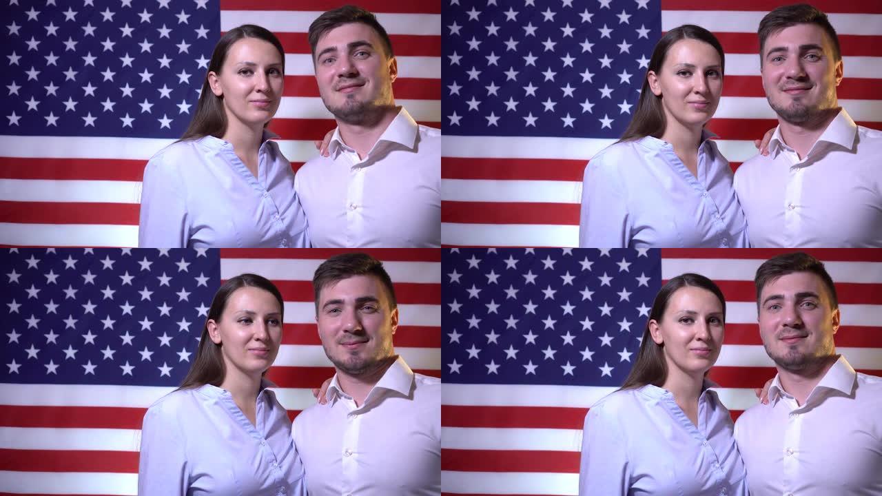 幸福的美国家庭美丽的男女在美国国旗的背景下，微笑着。