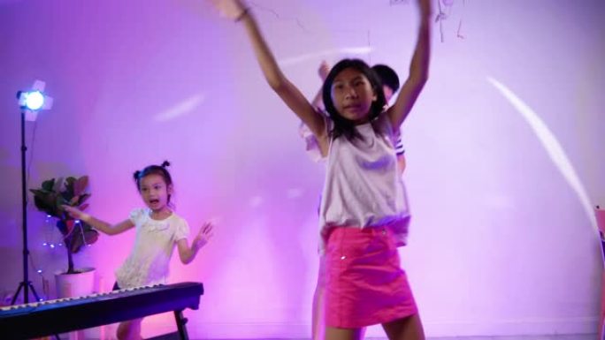 快乐的亚洲儿童在家庭聚会中跳舞，搭配led灯，生活方式理念。