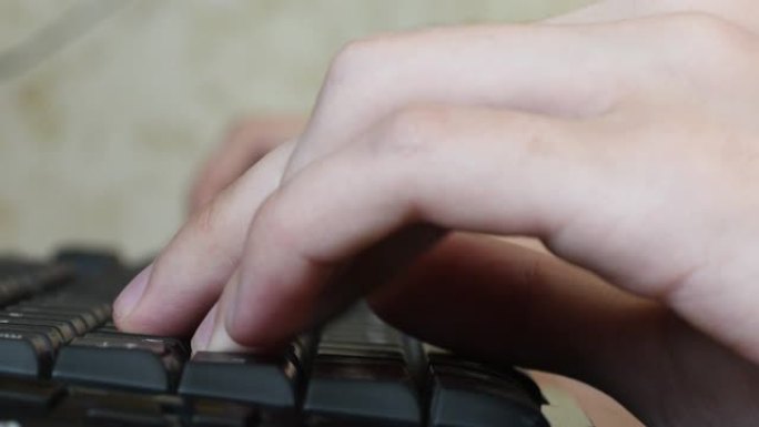 青少年的手在玩网络游戏时快速按下电脑键盘按钮