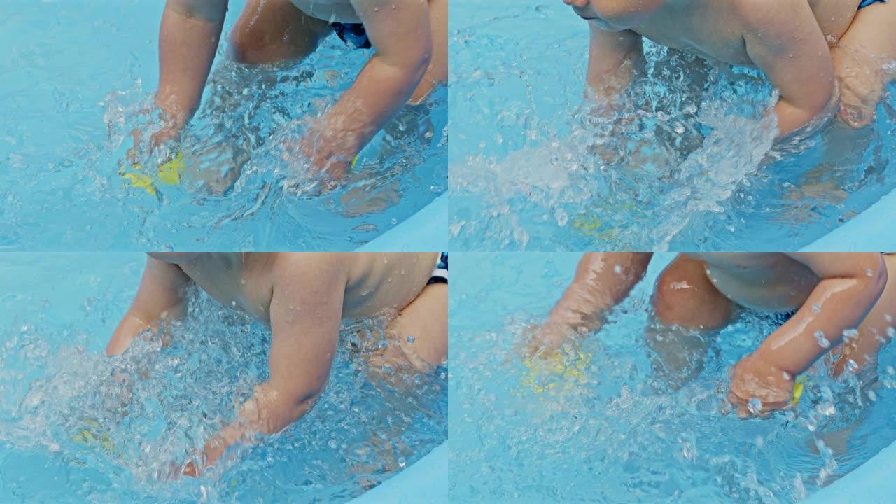 夏天，在户外游泳池游泳时，孩子的手和黄色的橡皮鸭一起泼水。小男孩玩得开心。健康生活方式、家庭、夏季休