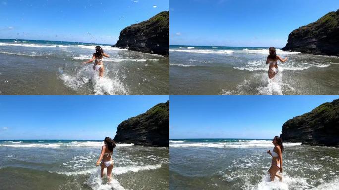 夏天在海滩上穿着比基尼的辣妹在水里奔跑