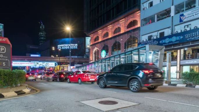 夜间，汽车在马来西亚城市街道的红绿灯处停下来。