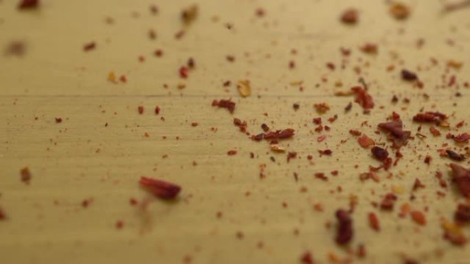 磨碎的辣椒落在木质表面上。红辣椒的宏观镜头。慢动作。