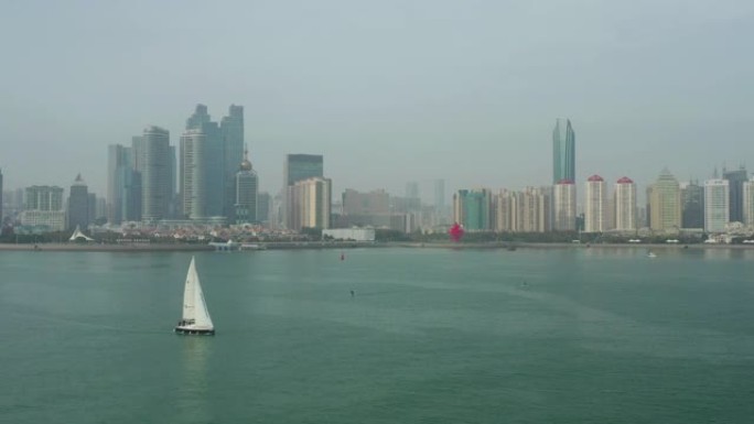 白天时间青岛市市中心海岸线海湾纪念碑帆船乘坐空中全景4k中国