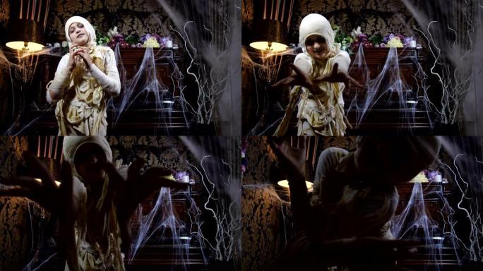 穿着万圣节木乃伊服装的女孩在古老的黑暗哥特式室内布满蜘蛛网和神秘雾的背景下摆姿势和吓人的电影镜头。4