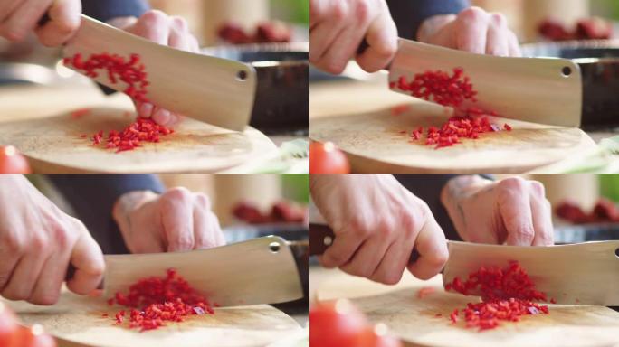 在木制砧板上煮红辣椒的手