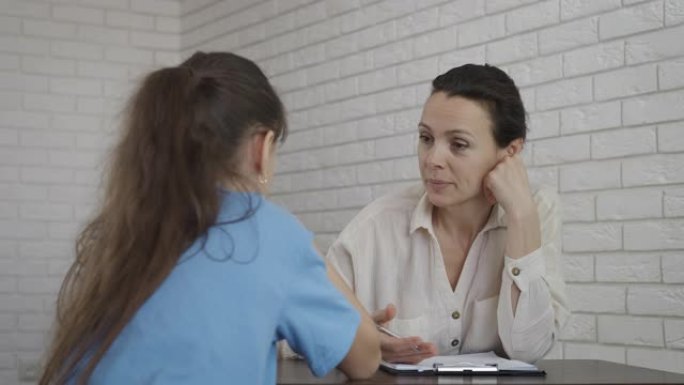 儿童心理学家和一个女孩说话。