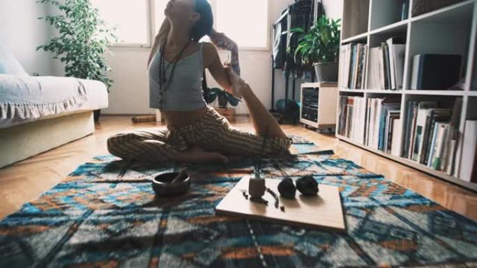 年轻女子做美人鱼瑜伽姿势，在家放松