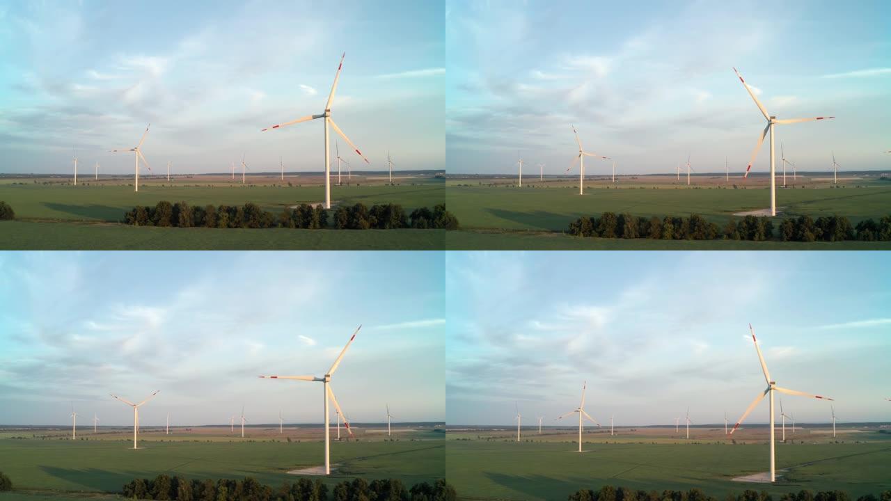 日落时绿色田野中的风力发电厂