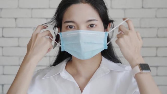 一位摘下口罩的亚洲妇女露出笑脸。